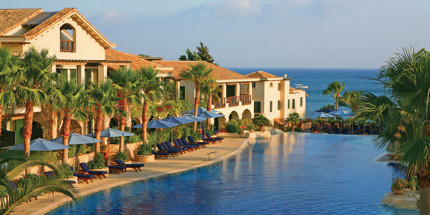 The resort's palm-fringed pool overlooks the sea