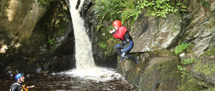 A gorge walker leaps into a plunge pool