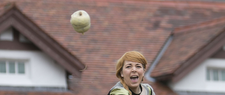 A lassie in traditional dress hurls a haggis