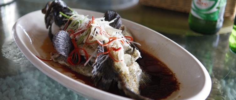 A steamed tiger grouper covered in cucumber and chilli shavings