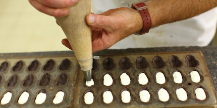 A master chocolatier fills freshly made pralines