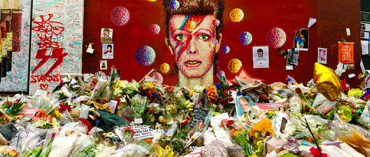 Flowers pile up outside the Bowie mural in Brixton