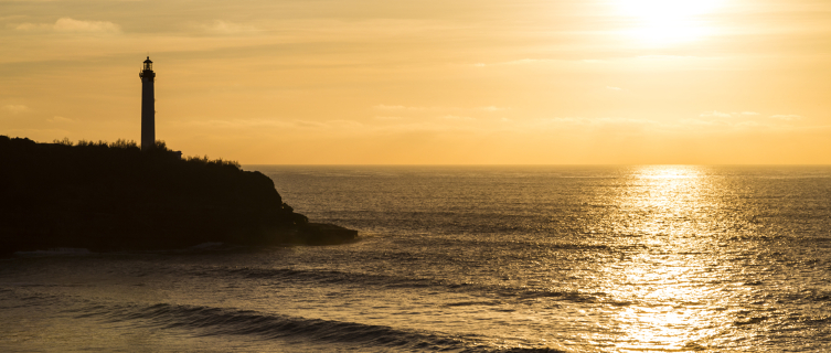 The sun setting over the Cape Hainsart lighthouse in Biarritz 